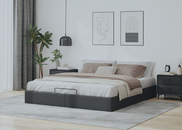 Lit ottoman rembourr&eacute; gris fonc&eacute; avec literie beige et tables de chevet fonc&eacute;es dans une chambre &agrave; coucher styl&eacute;e.