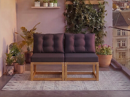 Canap&eacute; modulaire en bois deux places avec des coussins gris fonc&eacute; sur un balcon entour&eacute; de plantes en pot et une vue sur la ville en arri&egrave;re-plan