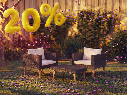 Fauteuils lounge d&rsquo;ext&eacute;rieur en rotin avec coussins et une petite table dans un cadre de jardin, d&eacute;cor&eacute;s de confettis roses et de ballons dor&eacute;s &laquo; 20 % de r&eacute;duction &raquo;, mettant en avant des offres saisonni&egrave;res sur les meubles lounge de jardin.