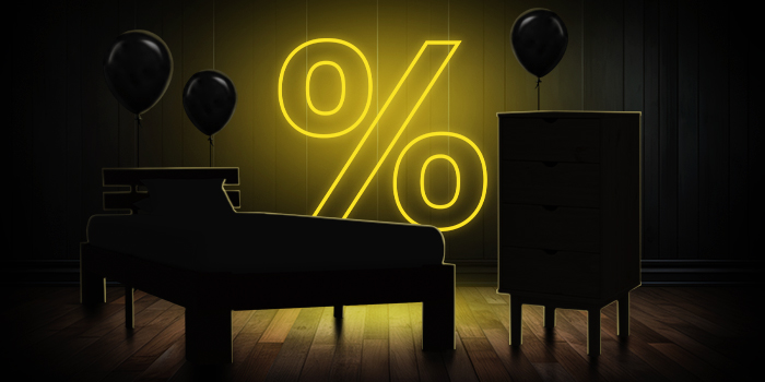  Lit noir et commode avec des ballons noirs devant un panneau de pourcentage jaune vif sur un plancher en bois sombre.